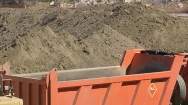 Kazı makinesi bir kamyona toprak taraması koyuyor.