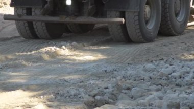 Bir inşaat alanında sanayi kamyonu çarkları tersine dönüyor.