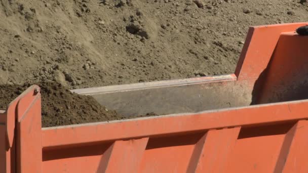 挖掘机在一辆工业卡车上卸下土地 — 图库视频影像