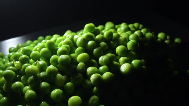 一堆堆鲜绿的豌豆 放在暗光的黑色盘子里 — 图库视频影像
