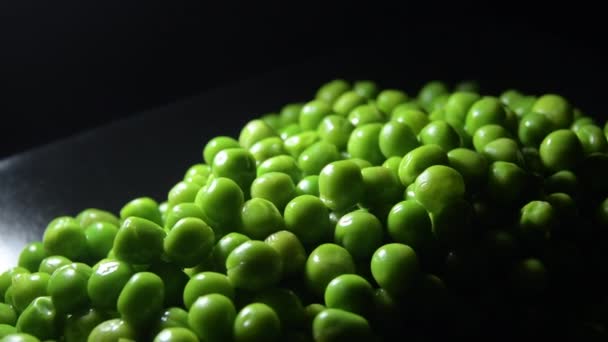 Grüne Erbsen Auf Einem Schwarzen Tablett Mit Intimem Licht — Stockvideo