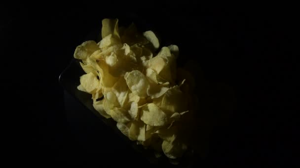 Kartoffelsplitterberg Auf Schwarzem Tablett Kreist Mit Intimem Licht — Stockvideo