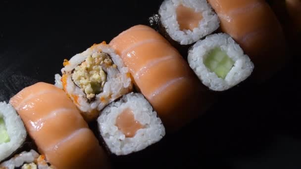 Conjuntos Rollos Sushi Con Salmón Una Bandeja Negra Girando Con — Vídeo de stock