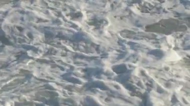Rough waves sea with white foam entering with force