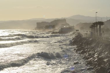 Waves sea breaking against the rocks with force at sunset