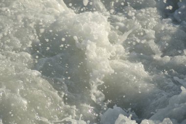 Gün batımında dalgalı beyaz köpük