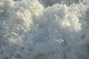 Beyaz köpüklü dalgalar güç kullanarak geliyor.