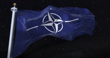 NATO Bayrağı gecenin ortasında yağmur ve karla dalgalanıyor. Döngü