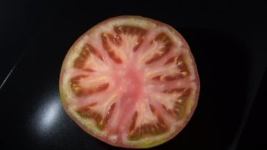 Siyah tepside kesilmiş olgun kırmızı domates.