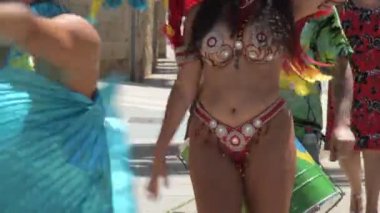 Kızlar samba yapıyor ve Brezilya sokak geçidinde yürüyor.