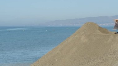 Kazı makinesi kumsala kum bırakıyor sahilin yenilenme çalışmaları için.