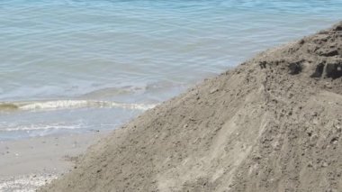 Plajların yenilenme çalışmalarına kum döken traktör.