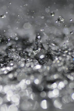 Damlalar sıçrıyor ve su birikintisine atlıyor.