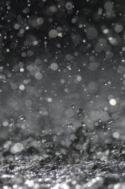 Drops splashing and jumping with force in a puddle water