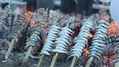 Sardalya espetoları popüler bir minenin içinde ateşte kızartılıyor.