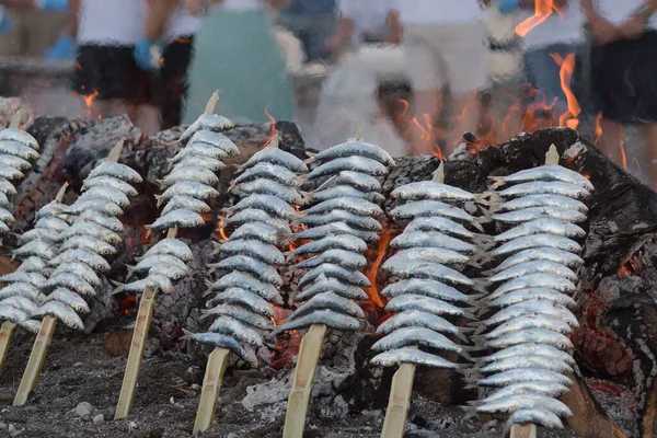 Sardines espetos grilled at fire outdoor, typical spanish food