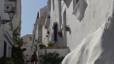 Endülüs 'ün beyaz caddesi güneşli bir günde yürüyenlerle dolu, Frigiliana, İspanya