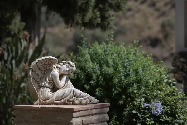 Angel dreaming, statue in the cemetery of Macharaviaya, Spain