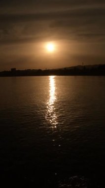 Gün batımında güneş ve deniz dalgaları. 4K Dikey