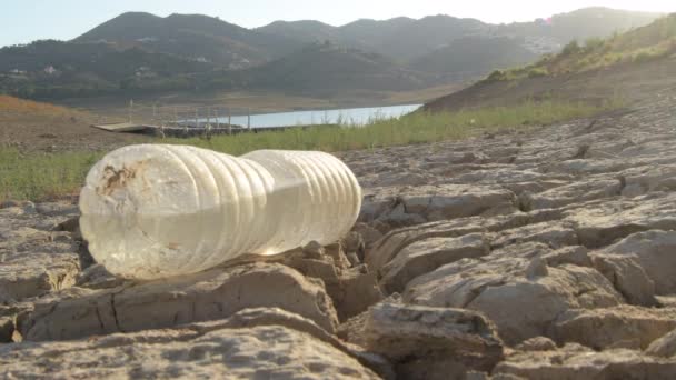 Botella Agua Abandonada Tierra Agrietada Por Sequía Juntos Pequeño Lago — Vídeos de Stock