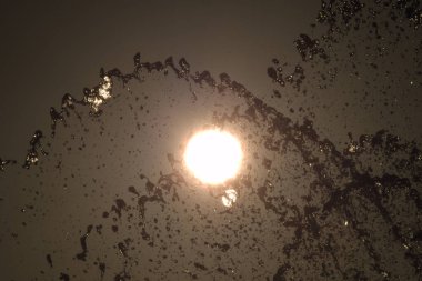 Gün batımında su sıçraması arasında güneş