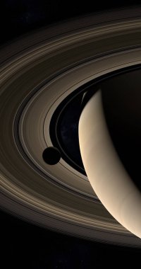 Moon orbiting around Saturn planet and her rings in the outer space