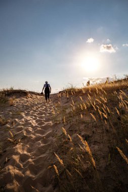 Yalnız adam gün batımında çölde yürüyor..