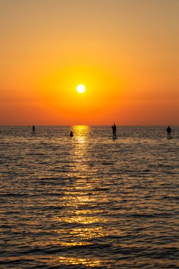 Deniz adasında gün doğumu sunucularla birlikte..