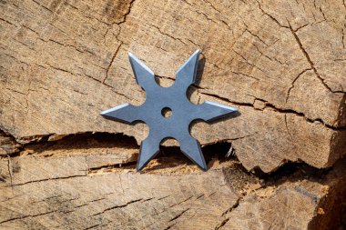 Shuriken (fırlatma yıldızı), geleneksel Japon Ninja soğuk silahı ahşap arka planda sıkışmış