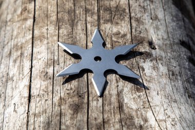 Shuriken (fırlatma yıldızı), geleneksel Japon Ninja soğuk silahı ahşap arka planda sıkışmış