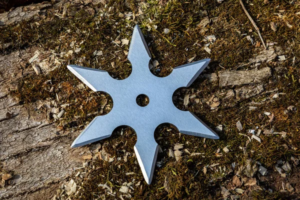 Shuriken (fırlatma yıldızı), geleneksel Japon Ninja soğuk silahı ahşap arka planda sıkışmış