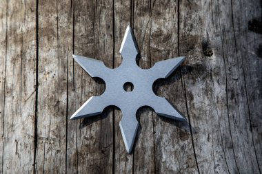Shuriken (fırlatma yıldızı), geleneksel Japon Ninja soğuk silahı ahşap arka planda sıkışmış