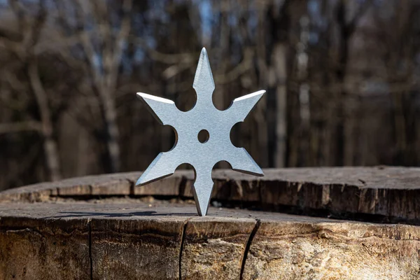 Shuriken (fırlatma yıldızı), geleneksel Japon Ninja soğuk silahı ahşap arka planda sıkışmış