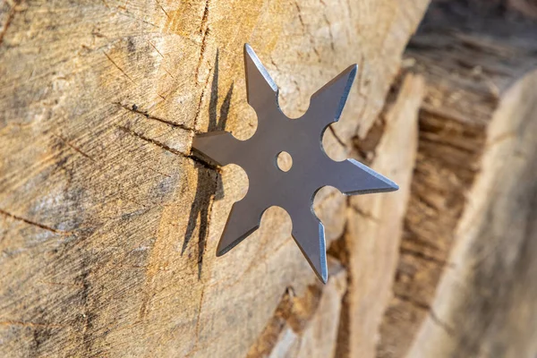 Shuriken (fırlatma yıldızı), geleneksel Japon Ninja soğuk silahı ahşap arka planda sıkışmış