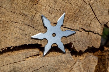 Shuriken (fırlatma yıldızı), geleneksel Japon Ninja soğuk silahı ahşap arka planda sıkışmış
