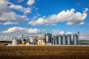 Tarım Siloları. Tahıl depolama ve kurutma tahıl, buğday, mısır, soya, ayçiçeği beyaz bulutlu mavi gökyüzüne karşı. Ekin depolama