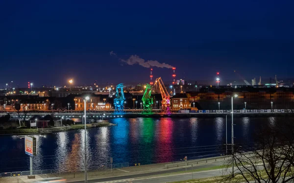 三台旧的港口起重机夜间在波兰什切青拉什托尼亚岛上的奥德拉河大道上发出五彩缤纷的灯光 从与恐龙相似的距离 — 图库照片