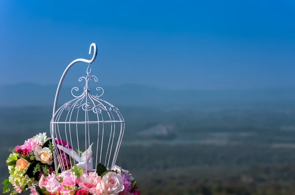 Gaiola de pássaro flores brancas e artificiais — Fotografia de Stock