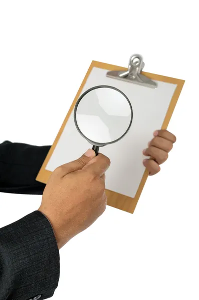 Бизнесмен проверяет документы с помощью лупы — стоковое фото
