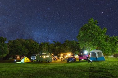 Lampang, Thailand - November 26, 2021 : Tourists camping at night, There are milky way galaxy in the sky. Chaloem Phrakiat Park, Thung Bua Tong, Mexican sunflower field, Mae Moh, Lampang, Thailand.
