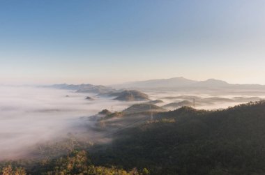 Yeşil ormandaki hava görüntüleme kulesi ve güzel bir sabah sisi. Enerji ve çevre kavramı. Yüksek voltajlı elektrik direkleri. Pang Puay, Mae Moh, Lampang, Tayland.