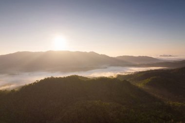 Yeşil dağlar ve yüksek voltaj direğiyle sabah ormanında sis. Pang Puai, Mae Moh, Lampang, Tayland.