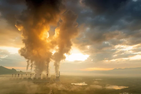 Aerial view coal power plant station in the morning mist, the morning sun rises. coal power plant and environment concept. Coal and steam. Mae Moh, Lampang, Thailand.