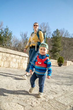 Mom on vacation with her son tied on a children's leash.