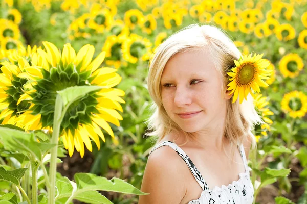 Jeune fille mignonne rêveuse dans le domaine des tournesols — Photo