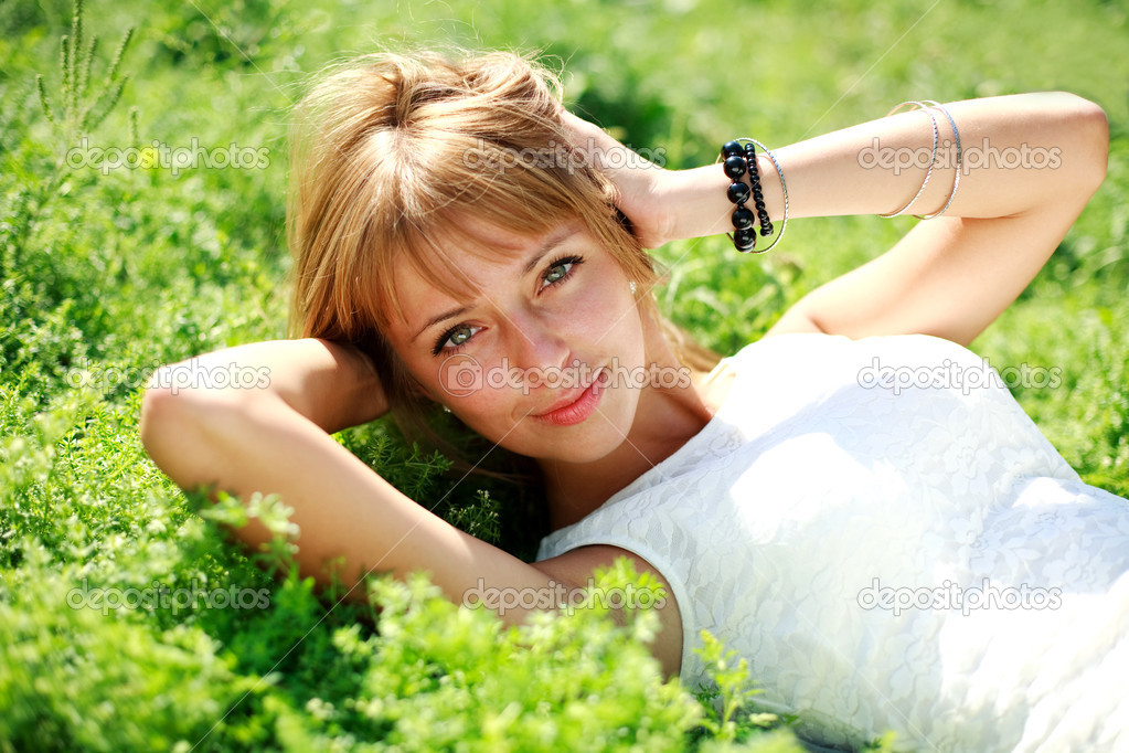 Beautiful young blonde woman on the green meadow