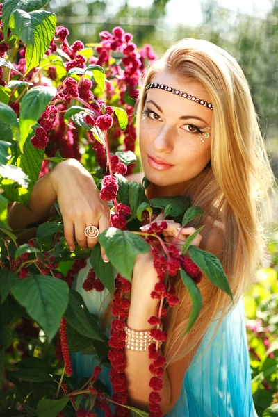 Retrato de bela menina de pé em flores vermelhas — Fotografia de Stock