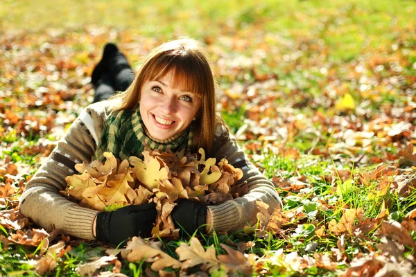 Açık havada yaprakları sarı ile oynarken sonbahar gülümseyen kız portresi — Stok fotoğraf