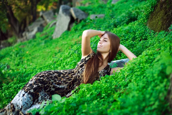 Sorridente ragazza sdraiata sull'erba verde da vicino, nel parco . — Foto Stock