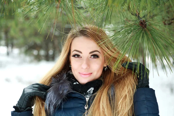 雪の冬の松林の美しい笑顔少女のクローズ アップの肖像画 — ストック写真